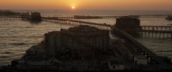 Movie still from “F9: The Fast Saga” (2021), directed by Justin Lin – An abandoned building in the middle of the ocean at sunset; Extreme Wide shot, High angle