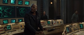 Movie still from “F9: The Fast Saga” (2021), directed by Justin Lin – A man and a woman are sitting at a table; Medium shot, Over the shoulder angle