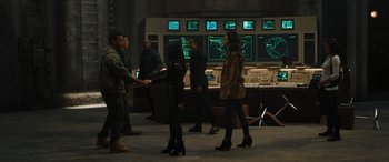 Movie still from “F9: The Fast Saga” (2021), directed by Justin Lin – A group of people standing in front of monitors; Wide shot, Over the shoulder angle