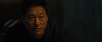 Movie still from “F9: The Fast Saga” (2021), directed by Justin Lin – A person wearing a black jacket; Close Up shot, High angle