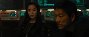 Movie still from “F9: The Fast Saga” (2021), directed by Justin Lin – A woman and a man are sitting next to each other; Close Up shot, Over the shoulder angle