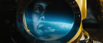 Movie still from “F9: The Fast Saga” (2021), directed by Justin Lin – A man's reflection in a porthole of a ship; Extreme Close Up shot, Overhead angle