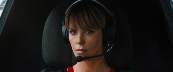 Movie still from “F9: The Fast Saga” (2021), directed by Justin Lin – A woman wearing a headset and looking into the distance; Close Up shot, High angle