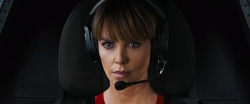 Movie still from “F9: The Fast Saga” (2021), directed by Justin Lin – A woman wearing a headset and looking into the camera; Close Up shot, High angle