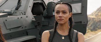 Movie still from “F9: The Fast Saga” (2021), directed by Justin Lin – A young woman with braids and a coin necklace; Close Up shot, Over the shoulder angle