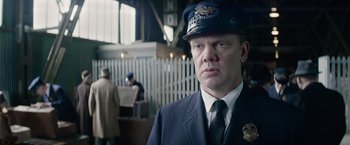 Movie still from “Fantastic Beasts and Where to Find Them” (2016), directed by David Yates – A man wearing a hat and a uniform; Close Up shot, Low angle