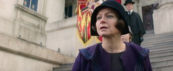Movie still from “Fantastic Beasts and Where to Find Them” (2016), directed by David Yates – A woman wearing a purple coat and a black hat; Close Up shot, Low angle