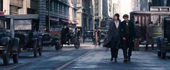 Movie still from “Fantastic Beasts and Where to Find Them” (2016), directed by David Yates – A woman walking down the street in a city; Wide shot, Low angle