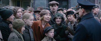 Movie still from “Fantastic Beasts and Where to Find Them” (2016), directed by David Yates – A group of people standing next to each other on the street; Medium shot, Low angle