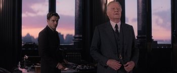 Movie still from “Fantastic Beasts and Where to Find Them” (2016), directed by David Yates – A man in a suit standing next to another man in a suit; Medium shot, Over the shoulder angle