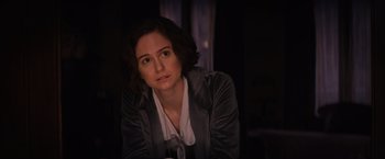 Movie still from “Fantastic Beasts and Where to Find Them” (2016), directed by David Yates – A woman sitting in a dark room looking at the camera; Close Up shot, Over the shoulder angle