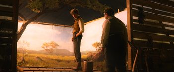 Movie still from “Fantastic Beasts and Where to Find Them” (2016), directed by David Yates – Two men standing in front of a painting of an outdoor scene; Wide shot, Low angle