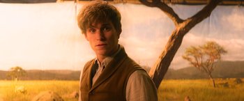 Movie still from “Fantastic Beasts and Where to Find Them” (2016), directed by David Yates – A man in a vest and tie standing in front of a tree; Close Up shot, Over the shoulder angle
