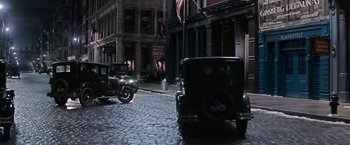 Movie still from “Fantastic Beasts and Where to Find Them” (2016), directed by David Yates – An old car is parked on the side of the street; Extreme Wide shot, High angle