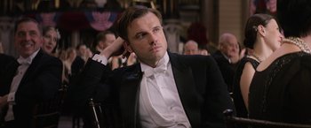 A man sitting in a chair wearing a tuxedo
