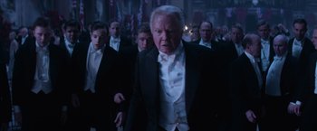 Movie still from “Fantastic Beasts and Where to Find Them” (2016), directed by David Yates – A group of men in tuxedos walking down a street; Medium shot, Low angle