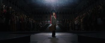 Movie still from “Fantastic Beasts and Where to Find Them” (2016), directed by David Yates – A man holding a briefcase standing in front of a crowd of onlookers; Wide shot, Low angle
