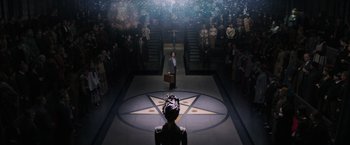 Movie still from “Fantastic Beasts and Where to Find Them” (2016), directed by David Yates – A man in a suit stands in front of an audience; Extreme Wide shot, High angle