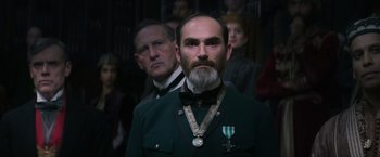 Movie still from “Fantastic Beasts and Where to Find Them” (2016), directed by David Yates – A man with a long beard wearing a medal around his neck; Close Up shot, Low angle