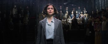 Movie still from “Fantastic Beasts and Where to Find Them” (2016), directed by David Yates – A woman standing in front of a group of people; Medium shot, Low angle