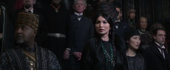 Movie still from “Fantastic Beasts and Where to Find Them” (2016), directed by David Yates – A woman in a black dress and a green hat; Close Up shot, Over the shoulder angle