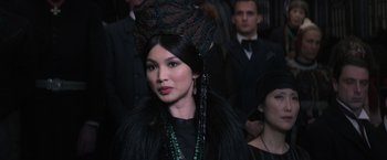 Movie still from “Fantastic Beasts and Where to Find Them” (2016), directed by David Yates – A woman in a black dress and a green hat; Close Up shot, Over the shoulder angle