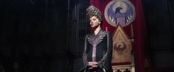 Movie still from “Fantastic Beasts and Where to Find Them” (2016), directed by David Yates – A woman wearing a crown standing in front of a wall; Medium shot, Low angle