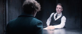 Movie still from “Fantastic Beasts and Where to Find Them” (2016), directed by David Yates – A man sitting at a table in front of another man; Medium shot, Over the shoulder angle