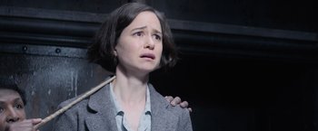 Movie still from “Fantastic Beasts and Where to Find Them” (2016), directed by David Yates – A woman holding a wooden stick in a dark room; Close Up shot, Over the shoulder angle
