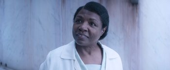 Movie still from “Fantastic Beasts and Where to Find Them” (2016), directed by David Yates – An older black woman wearing a white shirt and jacket; Close Up shot, Over the shoulder angle