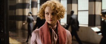 Movie still from “Fantastic Beasts and Where to Find Them” (2016), directed by David Yates – A person with curly hair wearing a scarf; Close Up shot, Over the shoulder angle