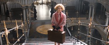 Movie still from “Fantastic Beasts and Where to Find Them” (2016), directed by David Yates – A woman holding a suit case on the stairs; Wide shot, High angle