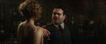 Movie still from “Fantastic Beasts and Where to Find Them” (2016), directed by David Yates – A man and a woman are standing in front of each other holding a wine glass; Close Up shot, Over the shoulder angle