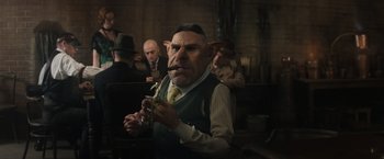 Movie still from “Fantastic Beasts and Where to Find Them” (2016), directed by David Yates – An old man with a goatee and a mustache; Medium shot, Over the shoulder angle