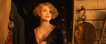 Movie still from “Fantastic Beasts and Where to Find Them” (2016), directed by David Yates – A woman with blonde curly hair wearing a black dress; Close Up shot, Low angle