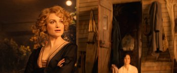 Movie still from “Fantastic Beasts and Where to Find Them” (2016), directed by David Yates – A woman in a black dress standing next to a door; Close Up shot, Over the shoulder angle