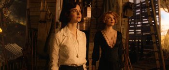 Movie still from “Fantastic Beasts and Where to Find Them” (2016), directed by David Yates – Two women standing next to each other in front of a brick wall; Medium shot, Low angle