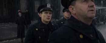 Movie still from “Fantastic Beasts and Where to Find Them” (2016), directed by David Yates – A group of men in uniform standing next to each other; Close Up shot, Over the shoulder angle