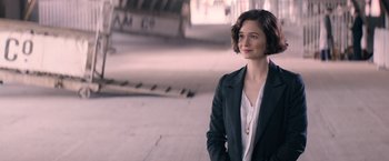 Movie still from “Fantastic Beasts and Where to Find Them” (2016), directed by David Yates – A woman in a suit standing in a parking lot; Close Up shot, Over the shoulder angle