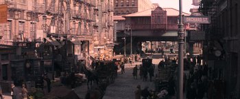 Movie still from “Fantastic Beasts and Where to Find Them” (2016), directed by David Yates – A city street filled with lots of people and carriages; Extreme Wide shot, High angle