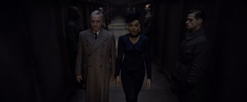 Movie still from “Fantastic Beasts: The Crimes of Grindelwald” (2018), directed by David Yates – A man and a woman walking down a hall way; Medium shot, Low angle