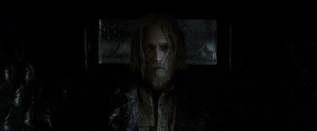 Movie still from “Fantastic Beasts: The Crimes of Grindelwald” (2018), directed by David Yates – A man with long hair and a long beard; Medium shot, Low angle