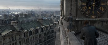 Movie still from “Fantastic Beasts: The Crimes of Grindelwald” (2018), directed by David Yates – A man standing on the side of a tall building; Extreme Wide shot, High angle
