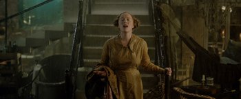 Movie still from “Fantastic Beasts: The Crimes of Grindelwald” (2018), directed by David Yates – A woman standing on the stairs of a building; Medium shot, Low angle
