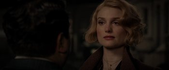 Movie still from “Fantastic Beasts: The Crimes of Grindelwald” (2018), directed by David Yates – A woman with blonde hair is looking at the camera; Close Up shot, Over the shoulder angle