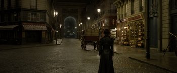 Movie still from “Fantastic Beasts: The Crimes of Grindelwald” (2018), directed by David Yates – A woman is standing in the middle of an empty street; Wide shot, Over the shoulder angle