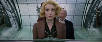 Movie still from “Fantastic Beasts: The Crimes of Grindelwald” (2018), directed by David Yates – A woman in a brown jacket is looking at the camera; Close Up shot, Low angle