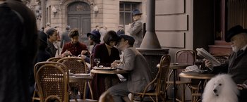 Movie still from “Fantastic Beasts: The Crimes of Grindelwald” (2018), directed by David Yates – A man and a woman are sitting at a table together; Wide shot, High angle