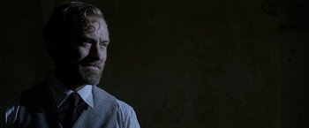 Movie still from “Fantastic Beasts: The Crimes of Grindelwald” (2018), directed by David Yates – A man with a goatee and a white dress shirt; Close Up shot, Over the shoulder angle