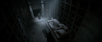 Movie still from “Fantastic Beasts: The Crimes of Grindelwald” (2018), directed by David Yates – A man kneeling down next to a statue of a person; Extreme Wide shot, Low angle